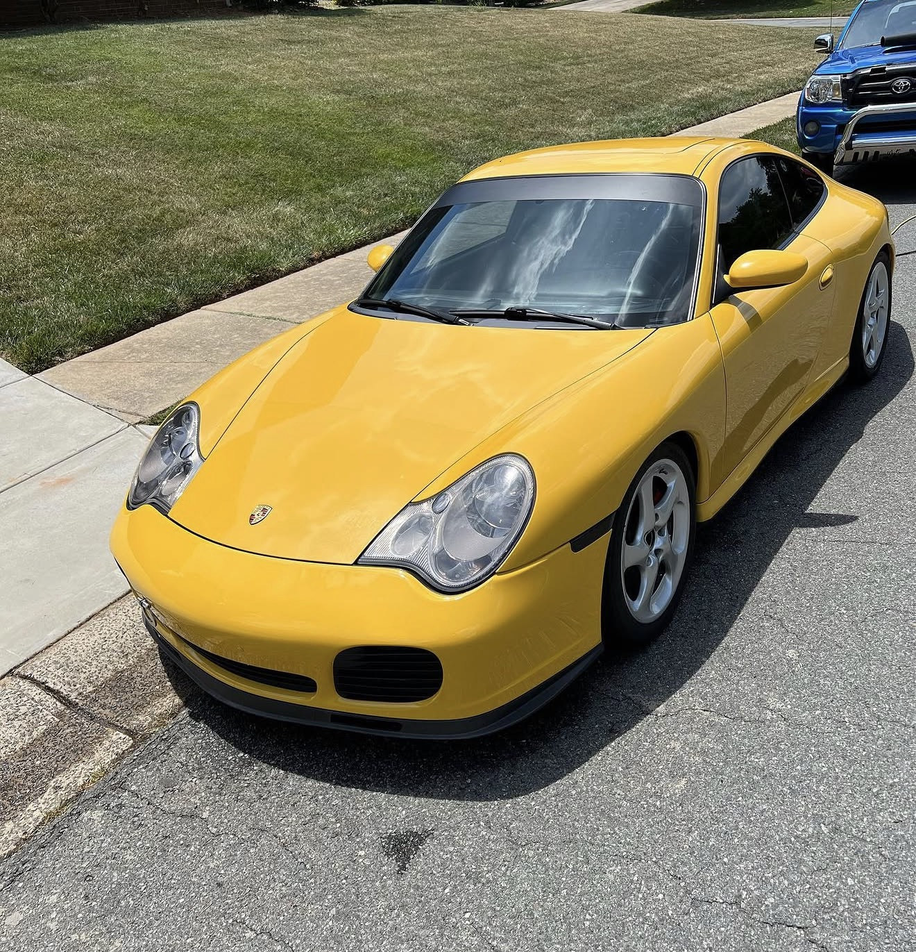Yellow Porsche coupe with a polished glossy exterior in a driveway